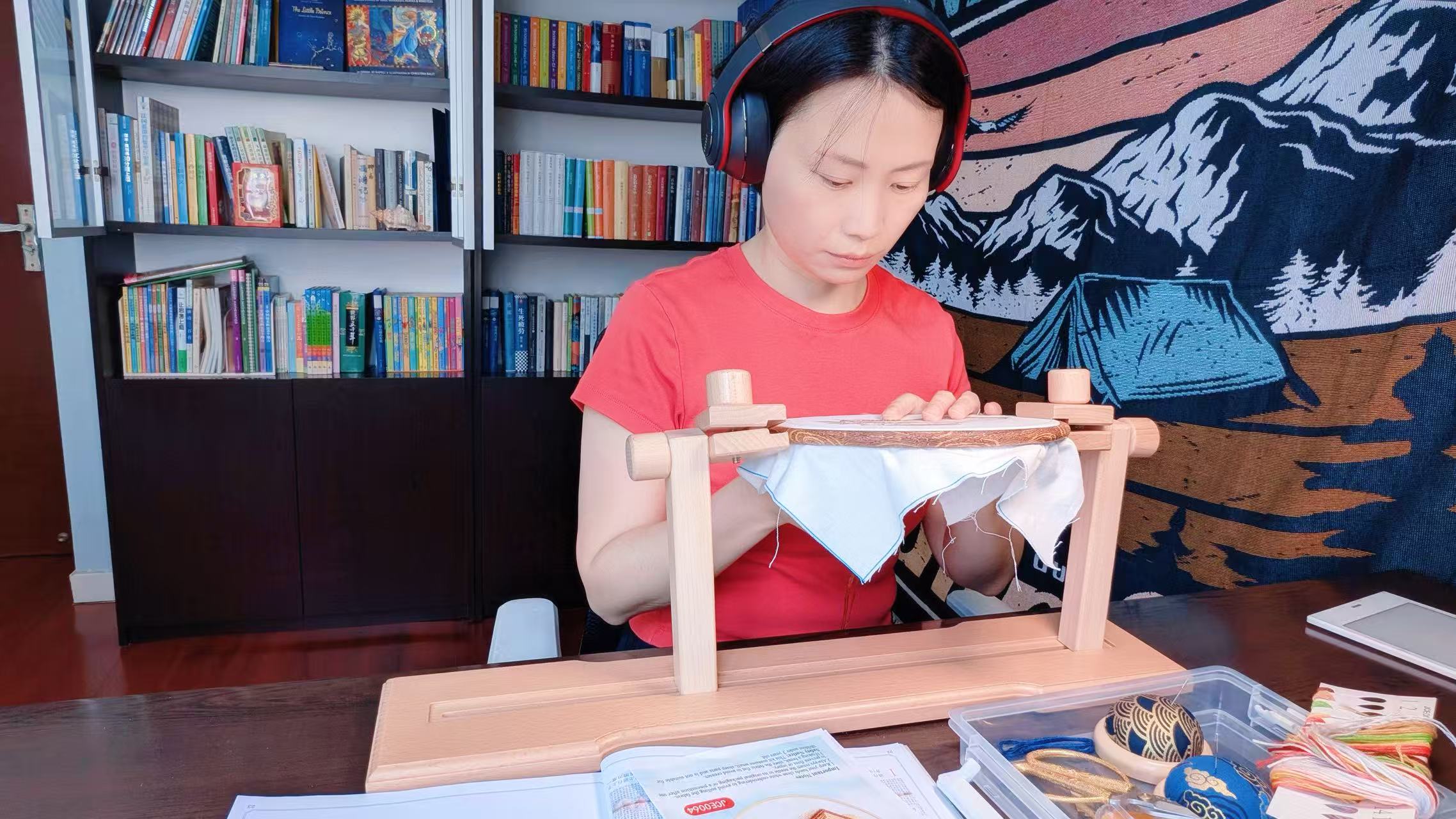 Nancy practicing stitch meditation in her reading room with a Story & Skein Moby Dick cross-stitch kit while listening to an audiobook.